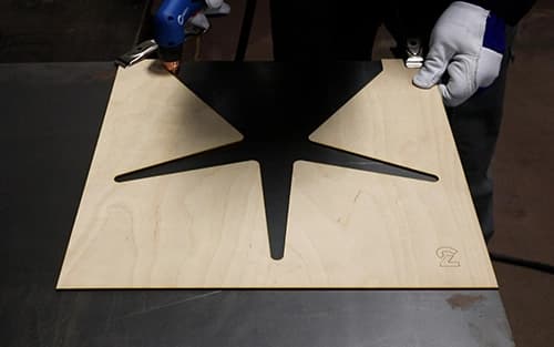 Operator laying wooden pattern on metal